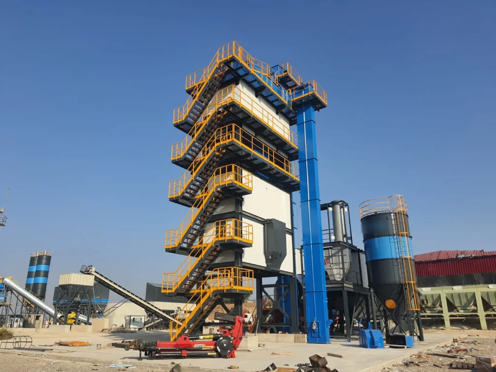 Asphalt batch plant mixing tower with access stairs, hot aggregate elevator and filler silo during installation